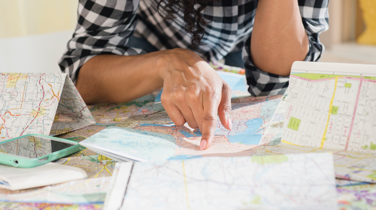 Woman with black & white checked shirt reading a travel map